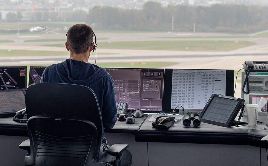 Air traffic controller at a radar screen overlooking the runway