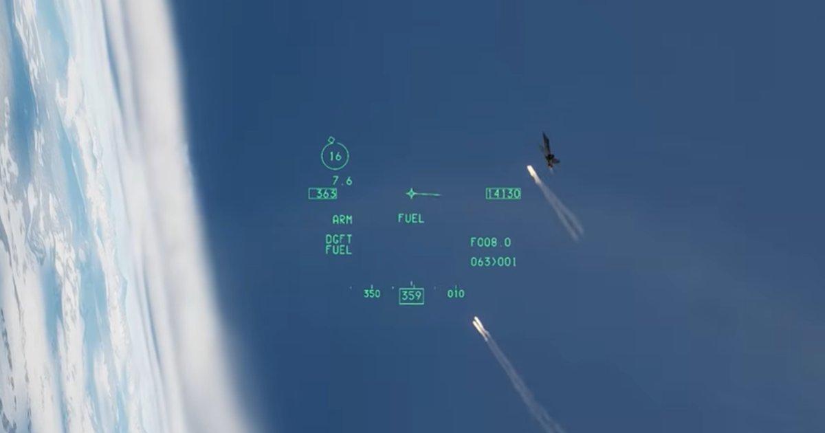 HUD view from a fighter jet in dogfight mode showing an enemy aircraft deploying flares against a blue sky, with DGFT symbology and targeting data visible